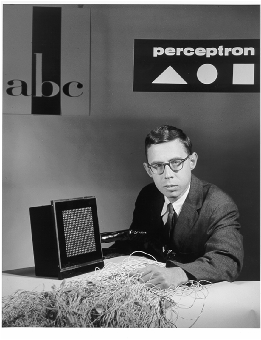 Frank Rosenblatt beside the Mark I Perceptron's sensor panel and wiring.